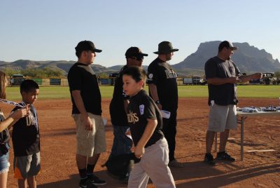 Black Diamondbacks coaches present end of season medals to the players on their team.